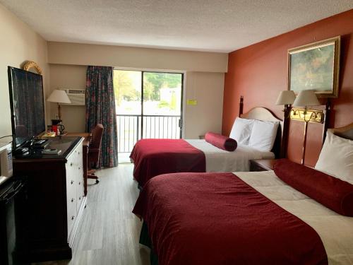 a hotel room with two beds and a balcony at Windsor Motel in Hope