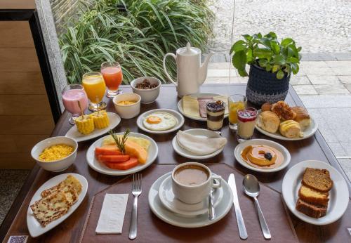a table with breakfast foods and drinks on it at Hotel Caiçara João Pessoa in João Pessoa
