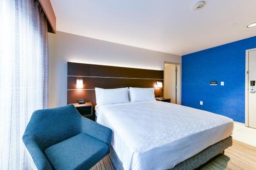 a bedroom with a bed and a blue chair at Holiday Inn Express Mill Valley San Francisco Area by IHG in Mill Valley