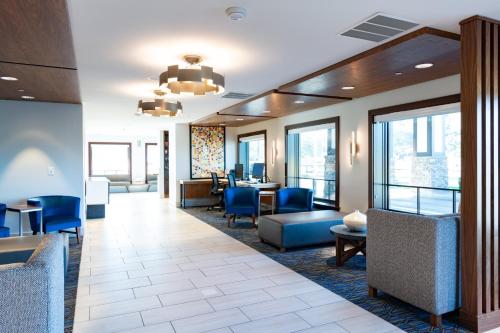 a lobby with blue chairs and tables and windows at Holiday Inn Express Mill Valley San Francisco Area, an IHG Hotel in Mill Valley