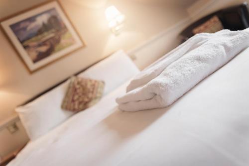a hotel room with a white towel on a bed at Elder York Guest House in Edinburgh