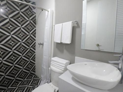a white bathroom with a sink and a toilet at Casa moderna equipada como hotel Habitacion 3 - baño afuera de la habitación in Monterrey