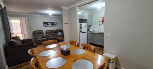 cocina y comedor con mesa de madera en Kubo House en Dubbo