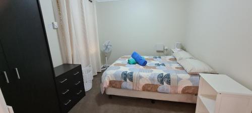 Un dormitorio con una cama con una almohada azul. en Kubo House en Dubbo