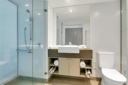 a bathroom with a toilet and a sink and a shower at Seascape Holidays at The Beach Club in Port Douglas
