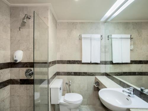 La salle de bains est pourvue de toilettes et d'un lavabo. dans l'établissement Asyana Kemayoran Jakarta, à Jakarta