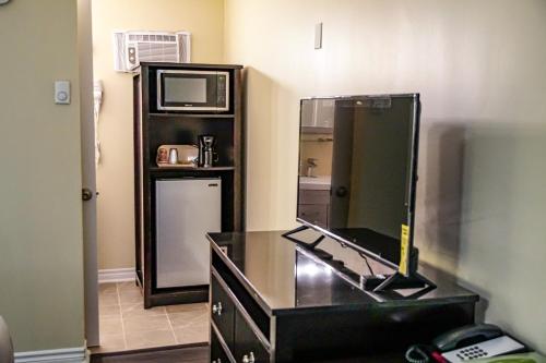 a bathroom with a dresser with a mirror on it at Skyland Motel Inn & Suites in Huntsville