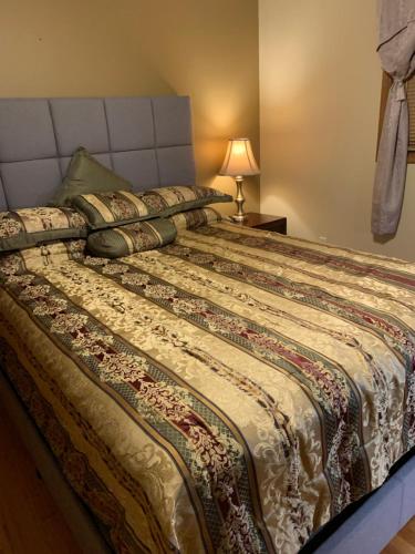 a bedroom with a large bed with a bedspread at Private Guest Bedroom - 2E East Room - Close to Lake Michigan in Sheboygan