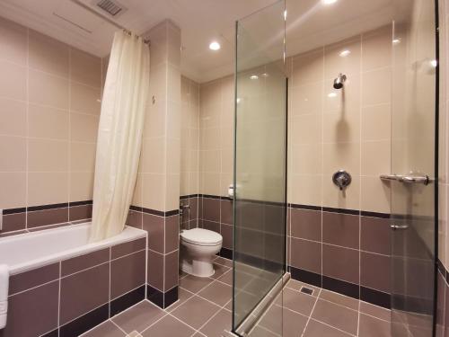 a bathroom with a toilet and a glass shower at Bayview Hotel Georgetown Penang in George Town