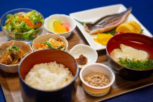a wooden tray with bowls of food on a table at Blue Cove Terrace in Miyako Island