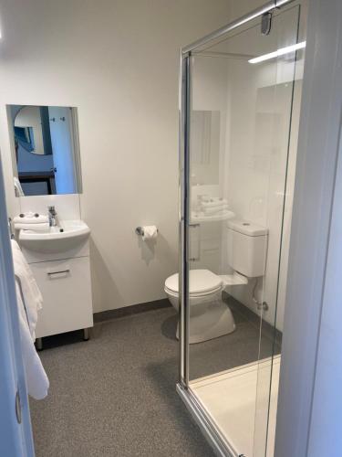 
a bathroom with a toilet, sink, and shower at Orford Blue Waters Hotel in Orford
