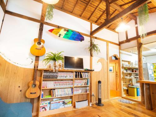 a living room with guitars hanging from the ceiling at Tabist Pumping Surf in Hyuga