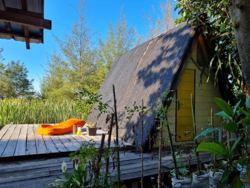 LhongaにあるSaho Coffee & Roomsの茅葺き屋根の木造デッキ建ての家