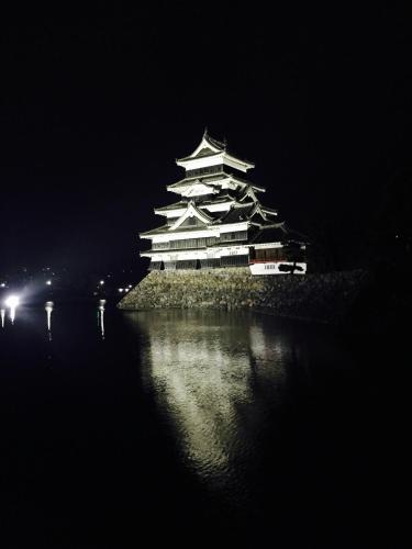 a large building on an island in the water at night at 松本はなれ Matsumoto HANARE - Japanese style private bedroom Guest hause in Matsumoto