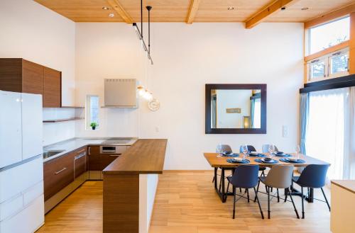 a kitchen and dining room with a table and chairs at Chalet Setsugekka in Hakuba