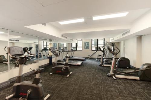 a gym with many treadmills and elliptical machines at YEHS Hotel Sydney Harbour Suites in Sydney