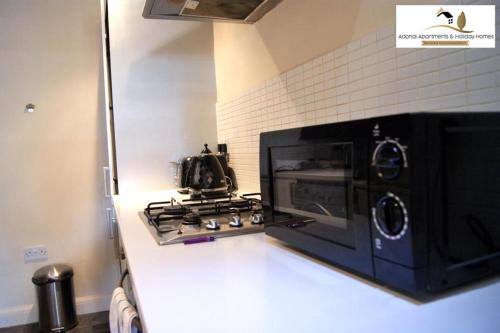 a microwave oven sitting on top of a kitchen counter at 2 Bedroom Apartment at Dagenham , Adonai Serviced Accommodation, Free WiFi and Parking in Dagenham