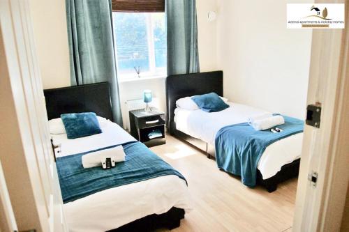 um quarto com 2 camas e uma janela em 2 Bedroom Apartment at Dagenham , Adonai Serviced Accommodation, Free WiFi and Parking em Dagenham