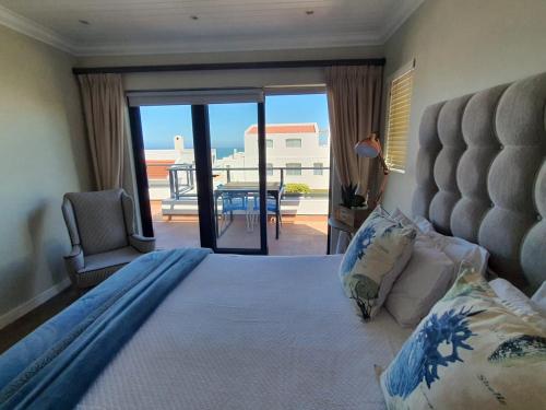 a bedroom with a bed with a view of a balcony at Langebaan Paradise Beach Self Catering 4 Elara in Langebaan