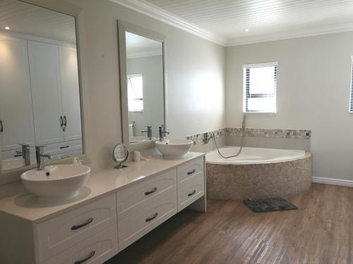 a bathroom with two sinks and a tub and a large mirror at Langebaan Paradise Beach Self Catering 4 Elara in Langebaan