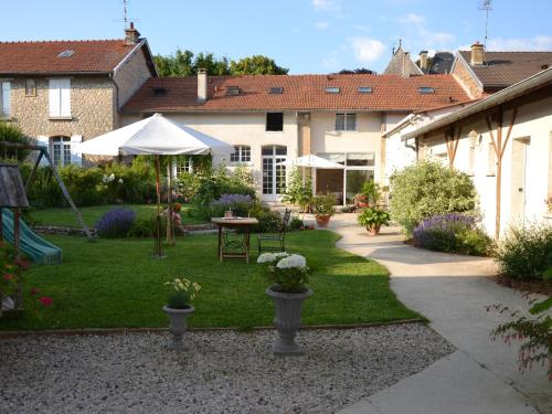 un jardín con mesa y sombrilla en Les Célestines, en Lavannes