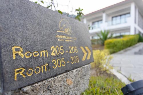 a sign in front of a house at Mountain Glory Forest Resort in Pokhara