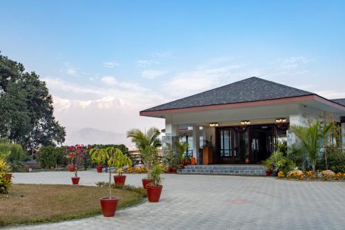 a building with potted plants in front of it at Mountain Glory Forest Resort in Pokhara
