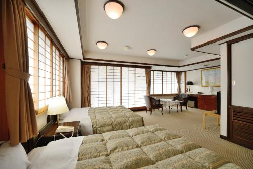 a hotel room with a large bed and a desk at Hotel Sunmi Club in Atami