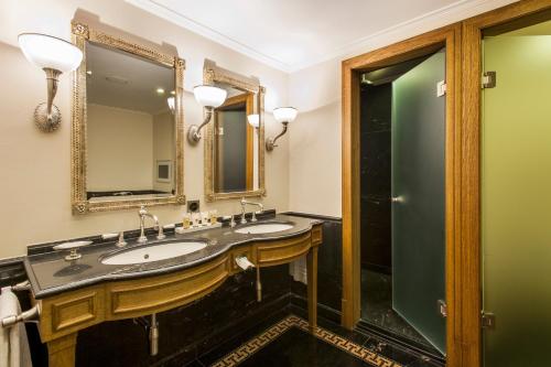 a bathroom with two sinks and a mirror at Grand Hotel LES TROIS ROIS in Basel