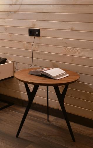 a table with a laptop and a book on it at Gudauri Hills Apart Hotel in Gudauri