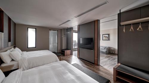 a bedroom with two beds and a flat screen tv at Yen Hotspring in Ruisui