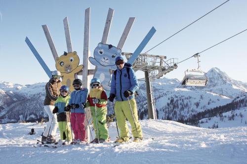 a group of people standing in the snow on a ski lift at Harmls Aparthotel in Flachau