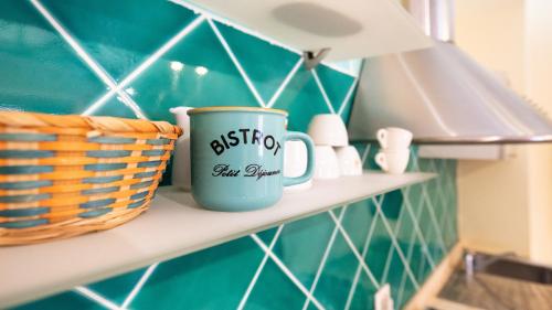 uma caneca de café azul sentada numa prateleira na cozinha em Welcomely - Piedra del Sol em Portoscuso