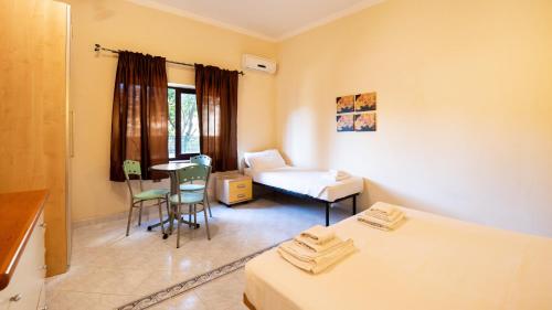 um quarto com duas camas e uma mesa e cadeiras em Welcomely - Piedra del Sol em Portoscuso