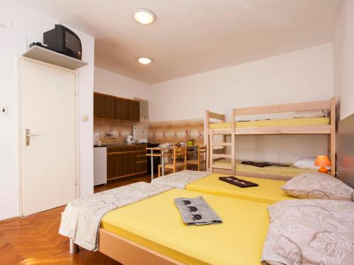 Duas camas num pequeno quarto com uma cozinha em Apartments Tanfara em Brodarica