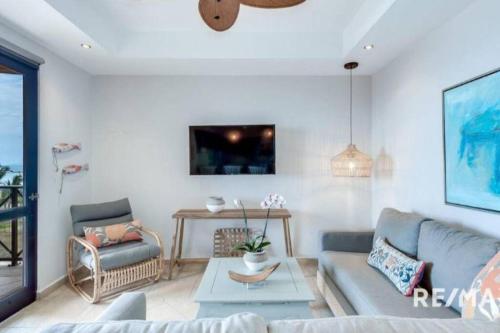 a living room with a couch and a table at 777J Beachfront Luxury Condo 3 BR/2.5BA Near SJO - Jaco Beach in Jacó