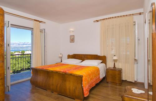 1 dormitorio con 1 cama grande y balcón en Holiday Home Lukrecia, en Supetar