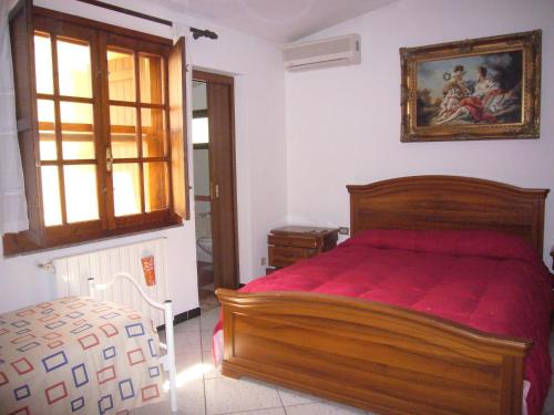 ein Schlafzimmer mit einem Holzbett mit einer roten Decke in der Unterkunft Su Barroccu in Riola Sardo