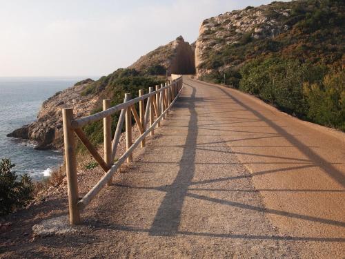 a road with a fence next to the ocean at Hotel Sunna Benicassim in Benicàssim