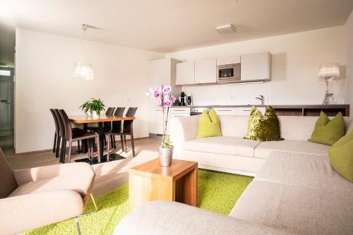 a living room with a white couch and a table at Tauernresidence Radstadt by ALPS RESORTS in Radstadt