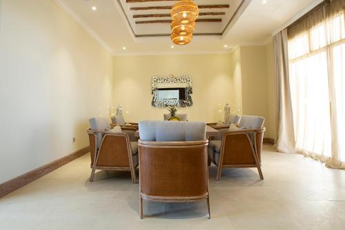 a dining room with a table and chairs and a television at Liwa Hotel in Mezairaa