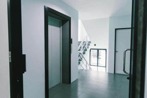 曼谷的住宿－AFP Residence Hotel，走廊设有黑色门,铺有瓷砖地板