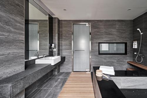 uma casa de banho com um lavatório e um espelho em Yen Hotspring em Ruisui