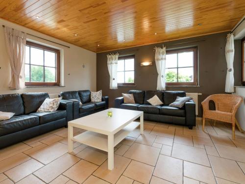 een woonkamer met banken en een tafel bij Magnificent Villa in Brisy with Sauna Roofed in Brisy