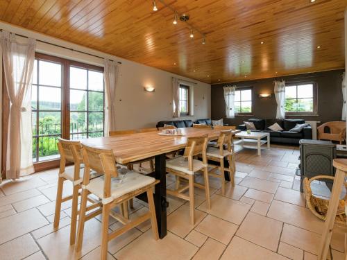 a dining room with a wooden table and chairs at Magnificent Villa in Brisy with Sauna Roofed Terrace and BBQ in Brisy