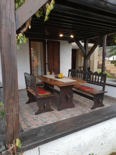 uma mesa de madeira e bancos num pátio em Kuća za odmor Breza em Legrad