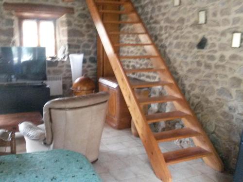 a wooden staircase in a room with a stone wall at Beautiful holiday home with mountain view in Sauvain