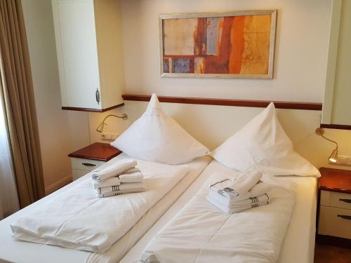 ヴェスターラントにあるSylter-Besserburg-App-4のホテルルーム(白い枕のベッド2台付)