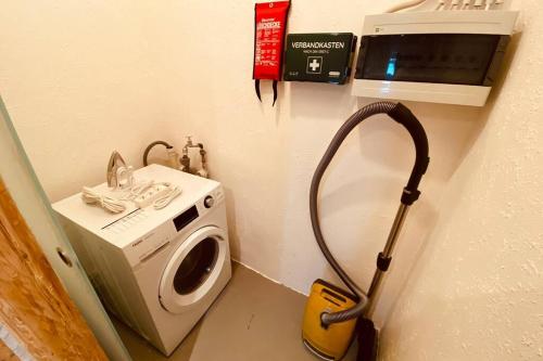 a room with a washing machine and a microwave at Gemütliche Landhaus Wohnung auf dem Ponyhof - Himmelbett, Kamin & Garten in Ortenberg