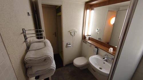 W łazience znajduje się umywalka, toaleta i lustro. w obiekcie Campanile Bordeaux Nord - Le Lac w mieście Bordeaux